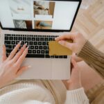 Person shopping online using a laptop and credit card, highlighting e-commerce convenience.
